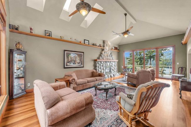 Living room featuring beamed ceiling, ceiling fan, a skylight, and wood finished floors | Image 15