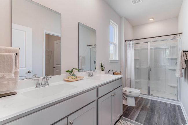 Bathroom featuring a shower stall, wood finished floors, and double vanity | Image 14