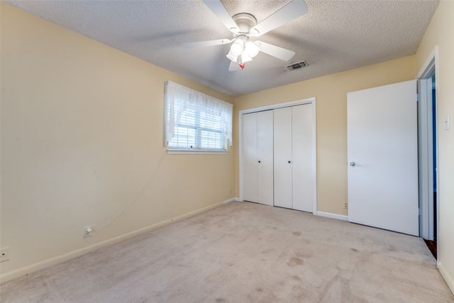 Unfurnished bedroom with carpet, baseboards, a closet, a textured ceiling, and a ceiling fan | Image 15