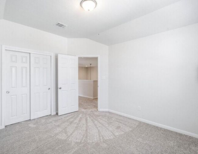 Unfurnished bedroom with carpet, a closet, and lofted ceiling | Image 17