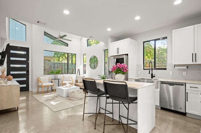Kitchen featuring appliances with stainless steel finishes, finished concrete flooring, tasteful backsplash, a ceiling fan, and recessed lighting | Image 13