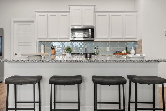 Kitchen with stainless steel microwave, a kitchen breakfast bar, and backsplash | Image 9