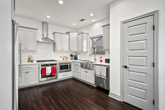 Gorgeous updated kitchen features high-end cabinetry, hardware & stainless steel appliances/apron-front sink. Timeless back splash & wide open space to include an island if you wish. | Image 7