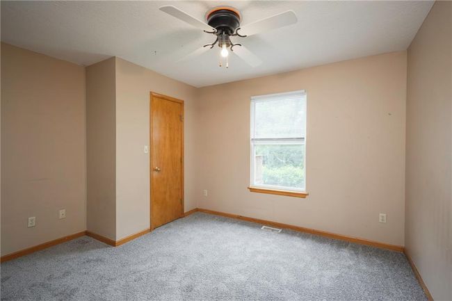 Empty room with light carpet, a ceiling fan, and baseboards | Image 22