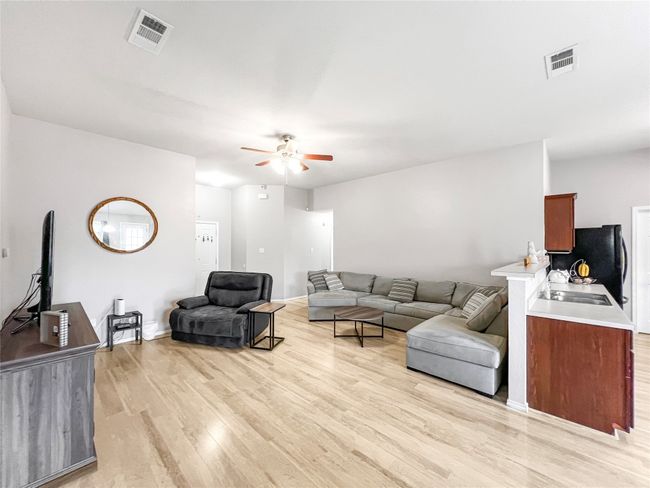 Living area with ceiling fan, light wood-type flooring, and baseboards | Image 16