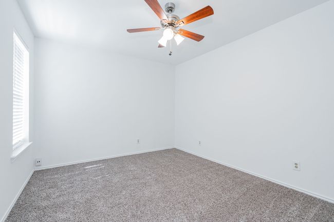 Carpeted empty room featuring baseboards, a ceiling fan, and a healthy amount of sunlight | Image 8