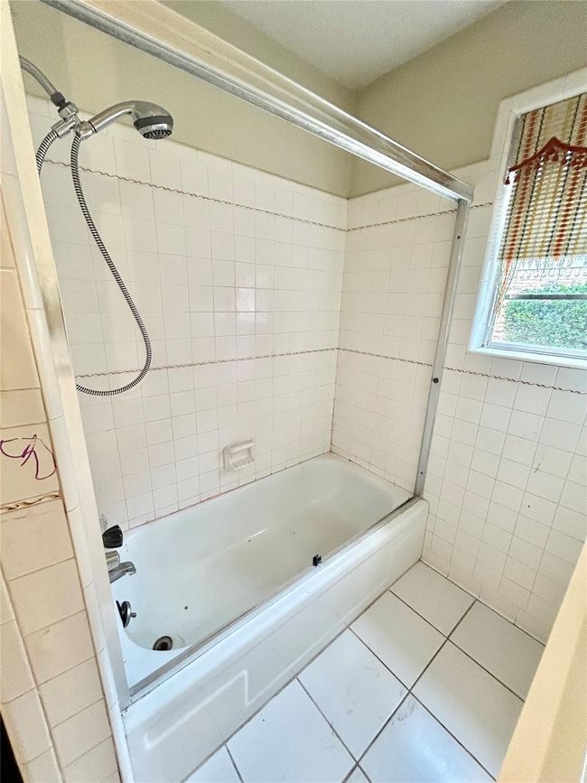 Full bathroom featuring tile patterned flooring, bathtub / shower combination, and tile walls | Image 16