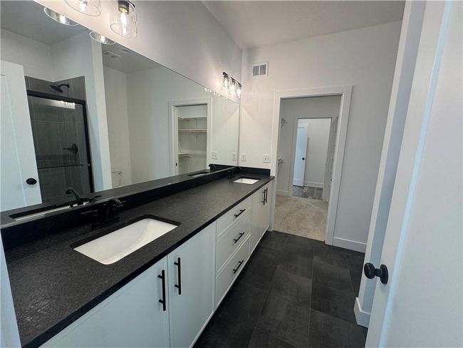 Full bathroom with visible vents, a sink, a stall shower, and double vanity | Image 14