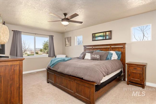 Bedroom featuring light carpet, a textured ceiling, and a ceiling fan | Image 11
