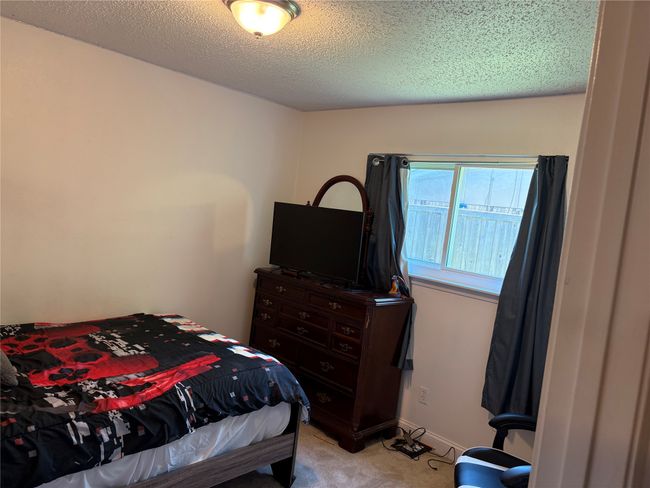 Bedroom featuring light colored carpet and a textured ceiling | Image 12