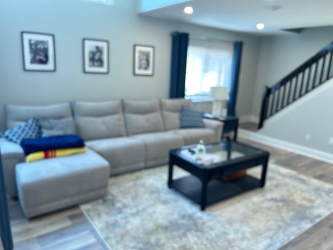 Living room with wood finished floors, baseboards, and stairs | Image 26