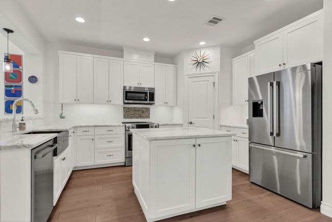 Kitchen with appliances with stainless steel finishes, white cabinets, recessed lighting, and dark wood-style flooring | Image 7