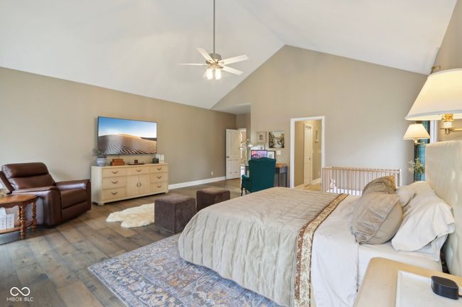 bedroom featuring baseboards, high vaulted ceiling, wood finished floors, and ceiling fan | Image 27