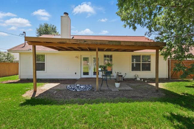 Back of property featuring french doors, a lawn, a chimney, and fence | Image 30