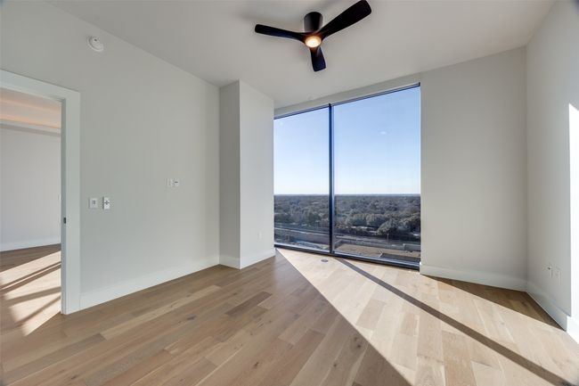 Spare room with ceiling fan, light wood-type flooring, and a wall of windows | Image 6