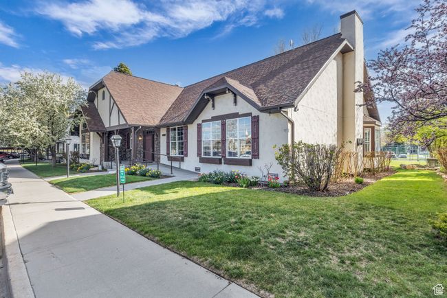 Tudor-style house with a front lawn, roof with shingles, stucco siding, and a chimney | Image 43