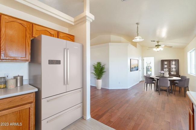 Digitally staged photo of the partial kitchen & the dining room. | Image 19