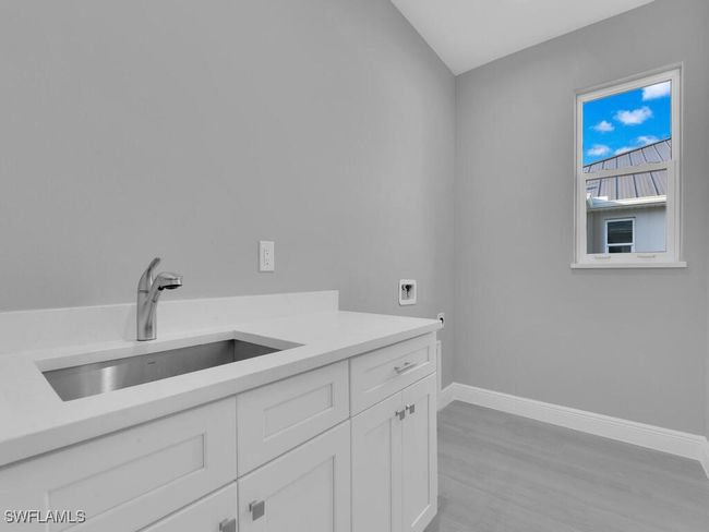 Washroom with cabinet space, hookup for a washing machine, and light wood-type flooring | Image 30