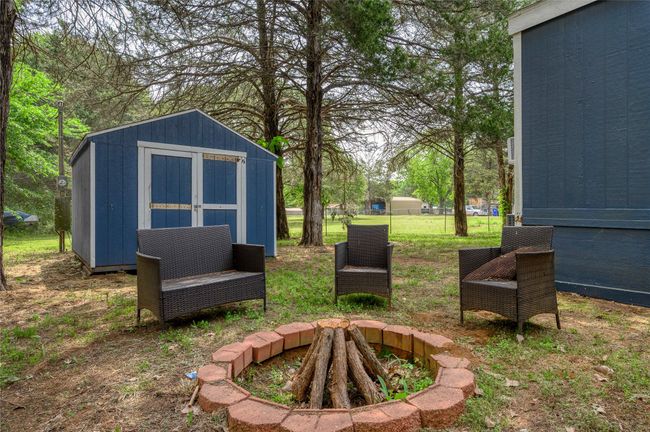 View of yard featuring a storage unit and an outdoor structure | Image 8