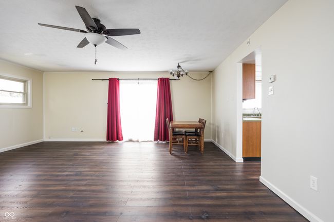 unfurnished room with healthy amount of natural light, dark wood finished floors, and a chandelier | Image 14