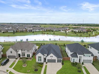 Amazing angle showcasing the stunning waterview, brick elevation, three-car garage, and luscious landscaping. | Image 1