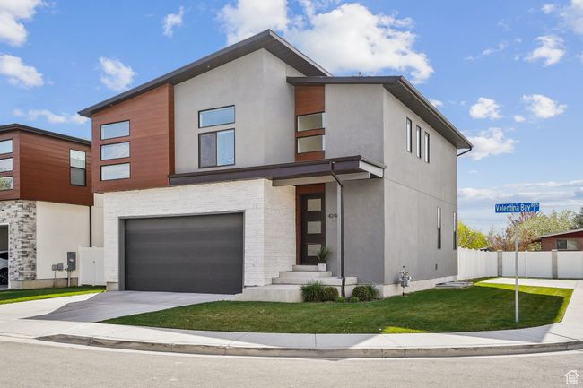 Contemporary house featuring a front lawn, driveway, fence, a garage, and stucco siding | Image 33