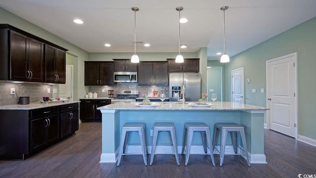 Kitchen featuring stainless steel appliances, dark wood-style flooring, decorative backsplash, and recessed lighting | Image 6