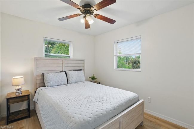 Bedroom with multiple windows, light wood-style floors, and ceiling fan | Image 23
