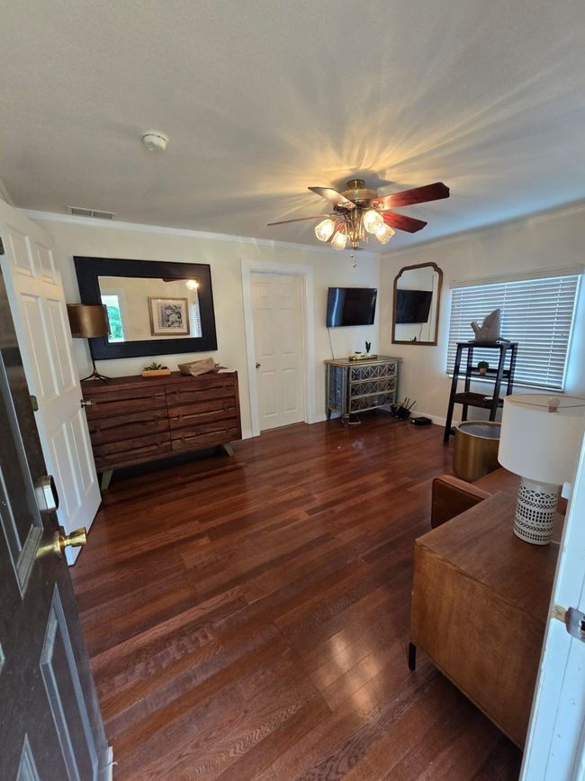 Living area featuring dark wood-style floors and a ceiling fan | Image 25