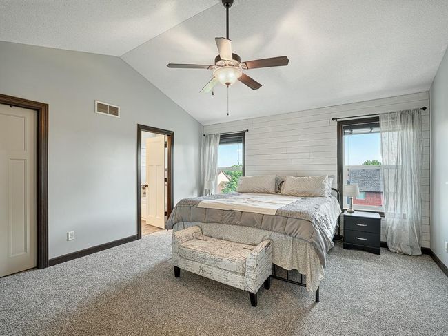 The primary suite has large windows, vaulted ceiling, an overhead fan, walk-in closet, and a spa-like bathroom, with a separate shower and soaking tub. | Image 19