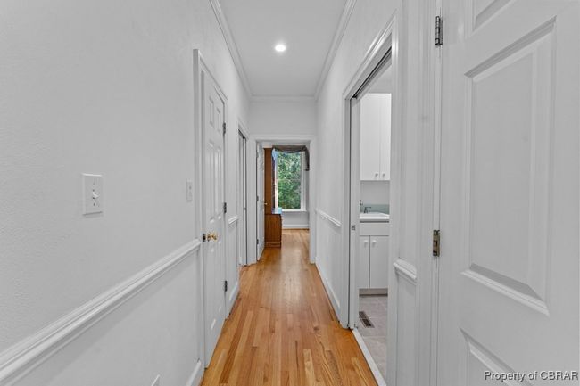 Corridor featuring light wood finished floors, crown molding, and recessed lighting | Image 33