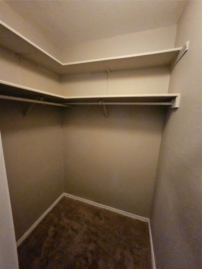 Spacious closet featuring dark colored carpet | Image 28