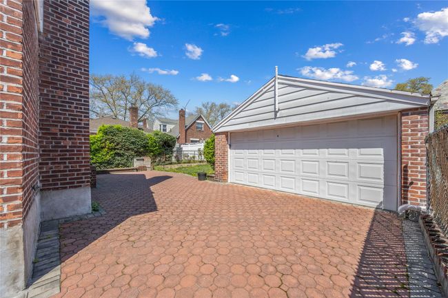 Garage with decorative driveway and fence | Image 17