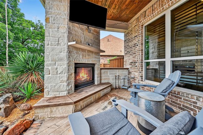 View of patio featuring an outdoor stone fireplace | Image 34