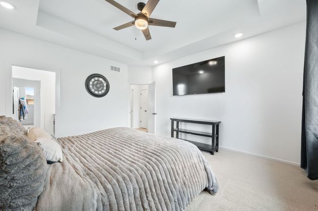 Bedroom featuring recessed lighting, carpet flooring, a raised ceiling, baseboards, and a ceiling fan | Image 16
