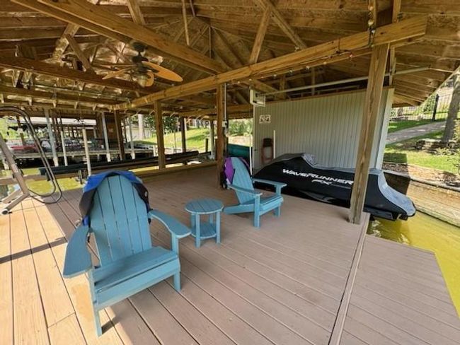 Experience waterfront luxury with a swim deck, boat lift, jet ski lift, and convenient metal stairs at the boathouse. | Image 44