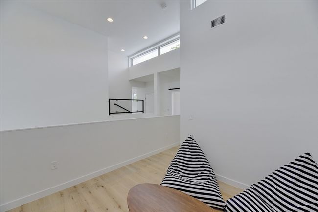 Living area featuring a towering ceiling, baseboards, recessed lighting, visible vents, and wood finished floors | Image 22