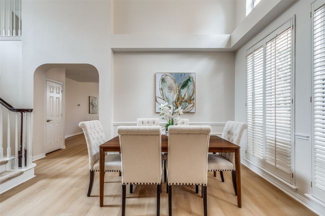 Dining area with arched walkways, stairway, a towering ceiling, light wood finished floors, and healthy amount of natural light | Image 7