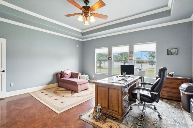 Office space featuring plenty of natural light, crown molding, a ceiling fan, and a tray ceiling | Image 22