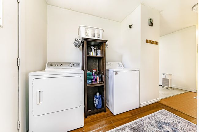 Laundry room featuring baseboards, wood finished floors, laundry area, and washer and clothes dryer | Image 14