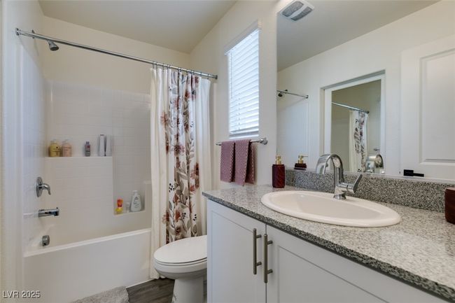 Bathroom featuring toilet, vanity, and shower / bath combination with curtain | Image 24