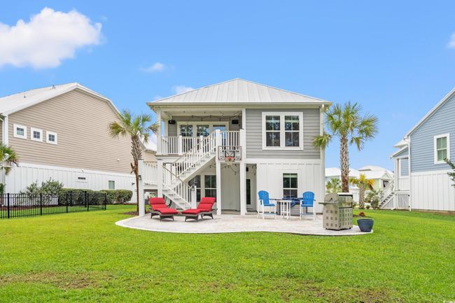 Back of house featuring stairs, a patio, and board and batten siding | Image 24