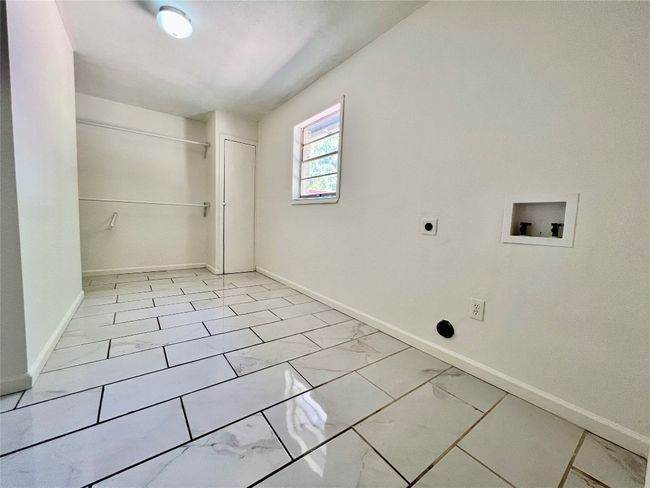 Laundry area featuring washer hookup, hookup for an electric dryer, light marble finish floors, and baseboards | Image 14