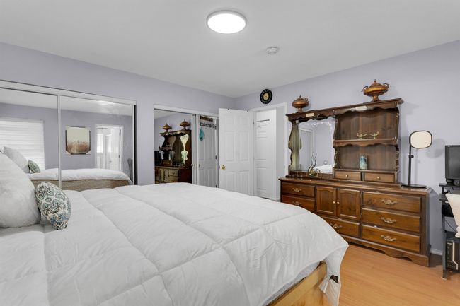 Bedroom featuring light wood-style floors and multiple closets | Image 9