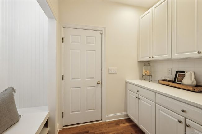 Mud room with bench and cabinets leads to the attached 2 car garage. | Image 17