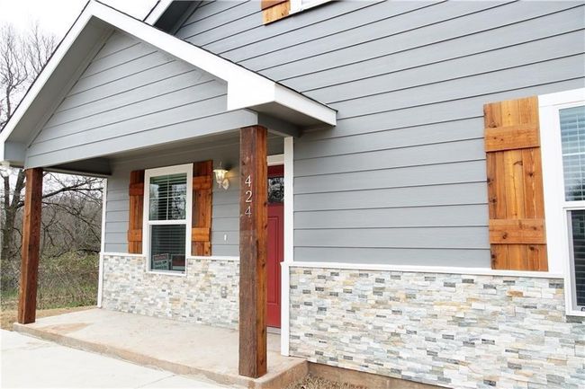 Doorway to property featuring covered porch and stone siding | Image 19