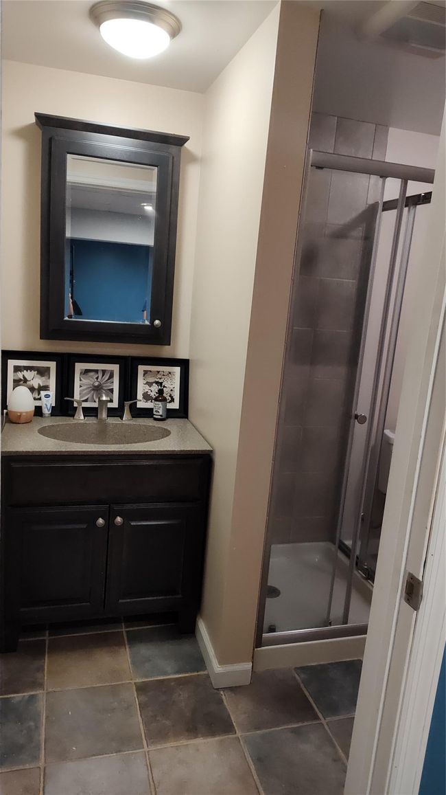 Bathroom featuring a stall shower, vanity, and baseboards | Image 8