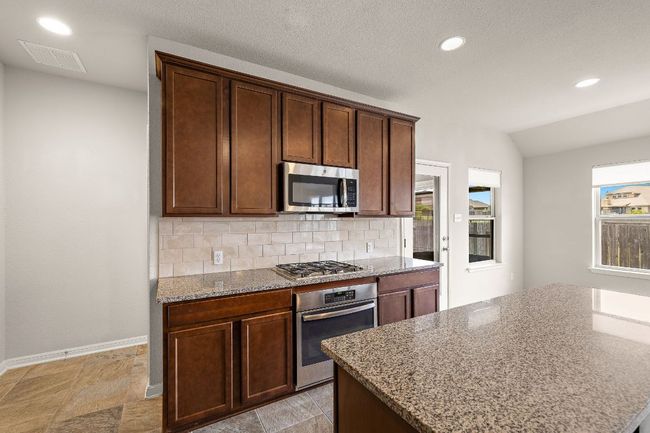 Kitchen with light stone counters, baseboards, appliances with stainless steel finishes, visible vents, and recessed lighting | Image 13