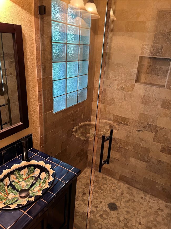 Full bathroom featuring a stall shower, vanity, and a textured wall | Image 19
