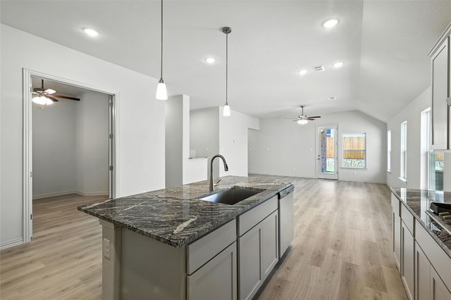 Kitchen with a ceiling fan, light wood-style floors, gray cabinets, lofted ceiling, and recessed lighting | Image 6
